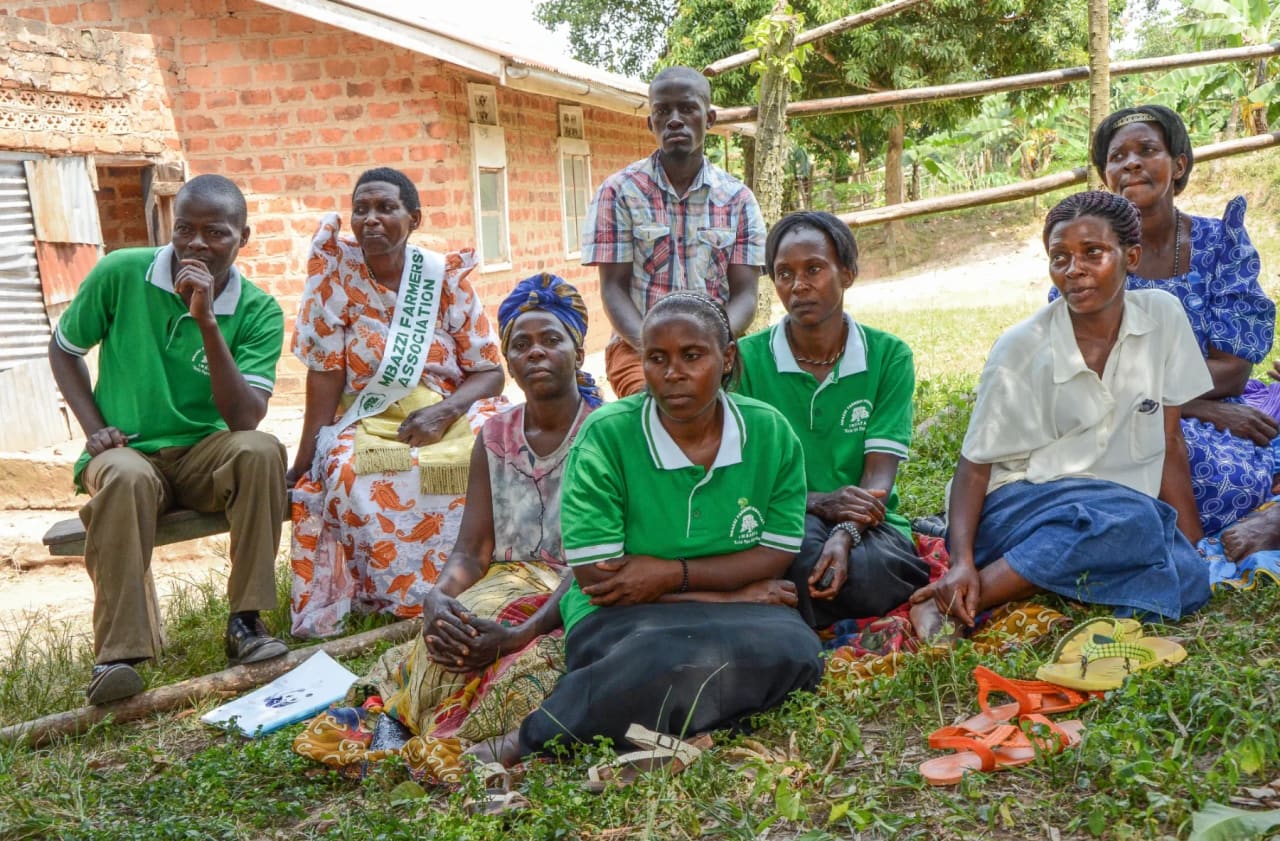 Members of a farmers’ association seated outdoors at a meeting