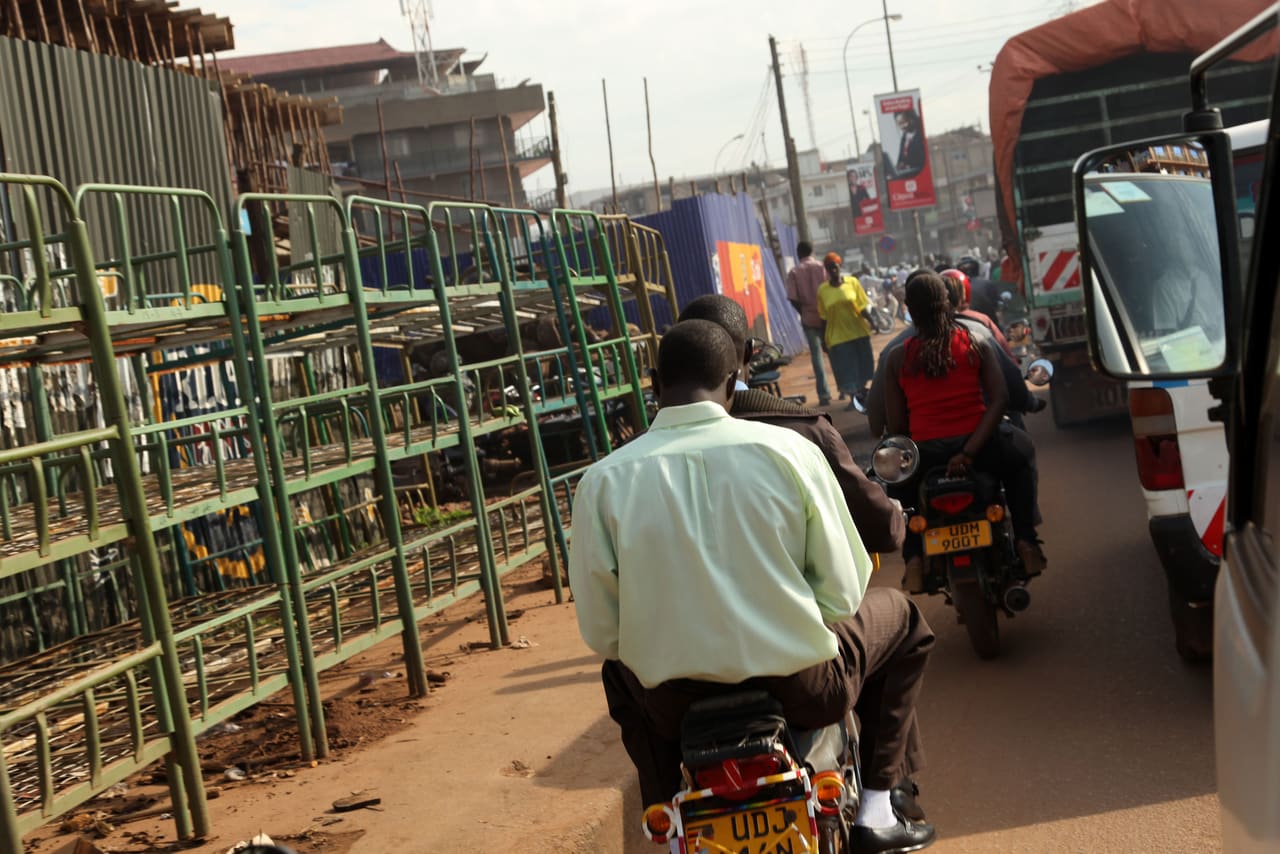 A motorcycle taxi and rider on a street in Kampala